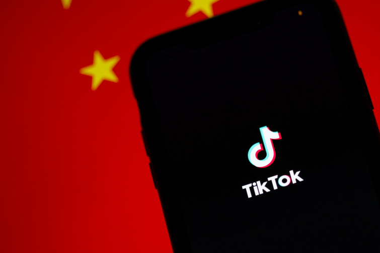 TikTok app on a mobile device with a Chinese flag behind it.